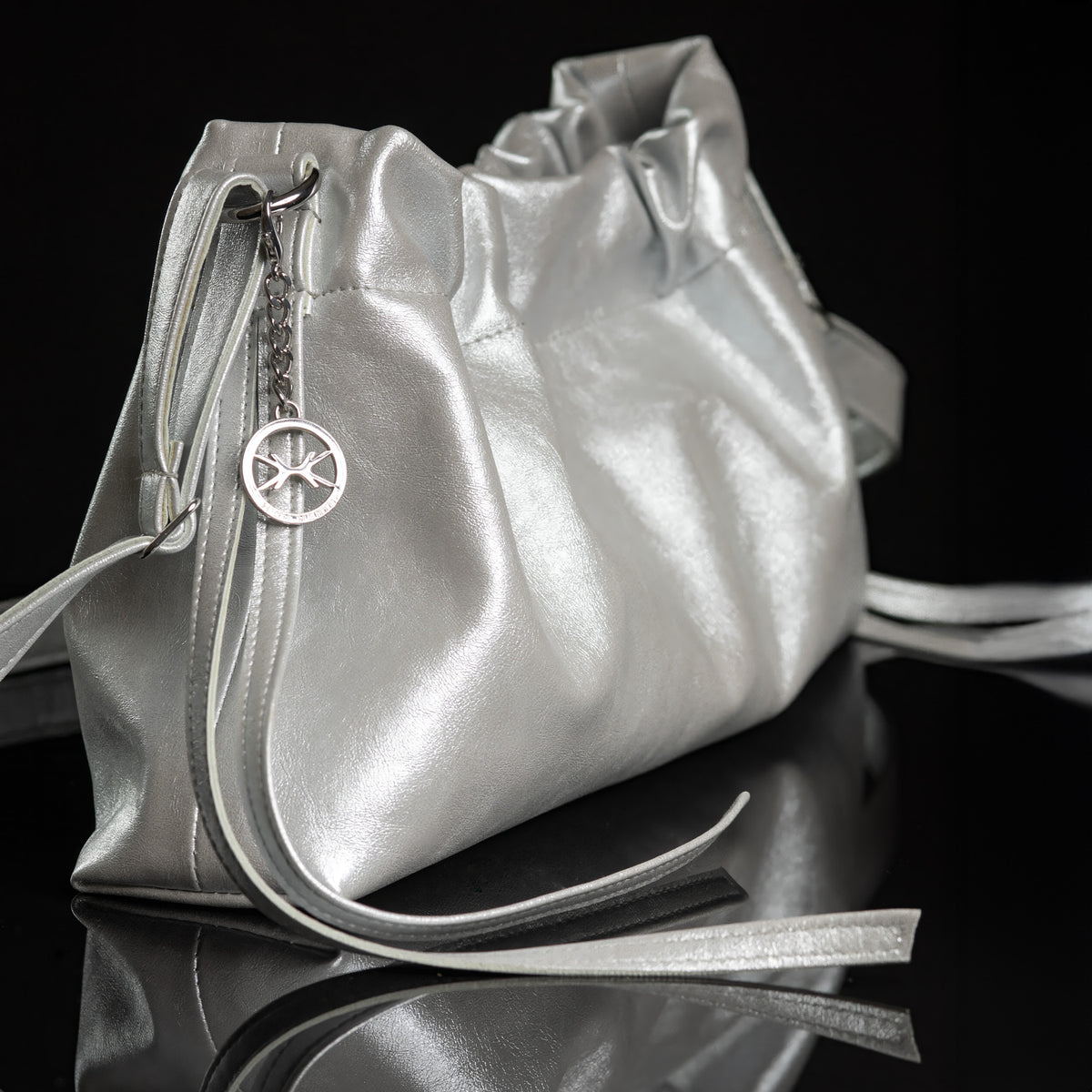 Pouch Bag Shiny Silver – Seitenansicht der Tasche in Silber-Metallic mit Herz-Anhänger